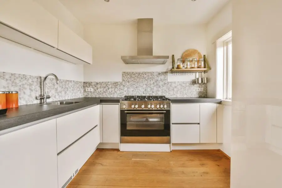 Spacious kitchen with white furniture and mosaic tiles